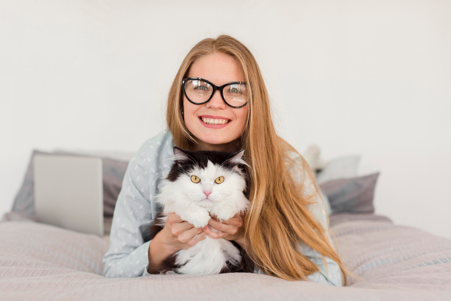 women sitting with her cat on a bed 